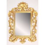 A LARGE FLORENTINE STYLE WALL MIRROR, 20TH CENTURY, with leaf and scroll carved wood, gesso,