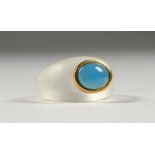 AN UNUSUAL CRYSTAL RING, inset with a blue stone.