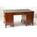 A LATE EDWARDIAN MAHOGANY PEDESTAL DESK, with gadrooned carved top, three frieze drawers, three