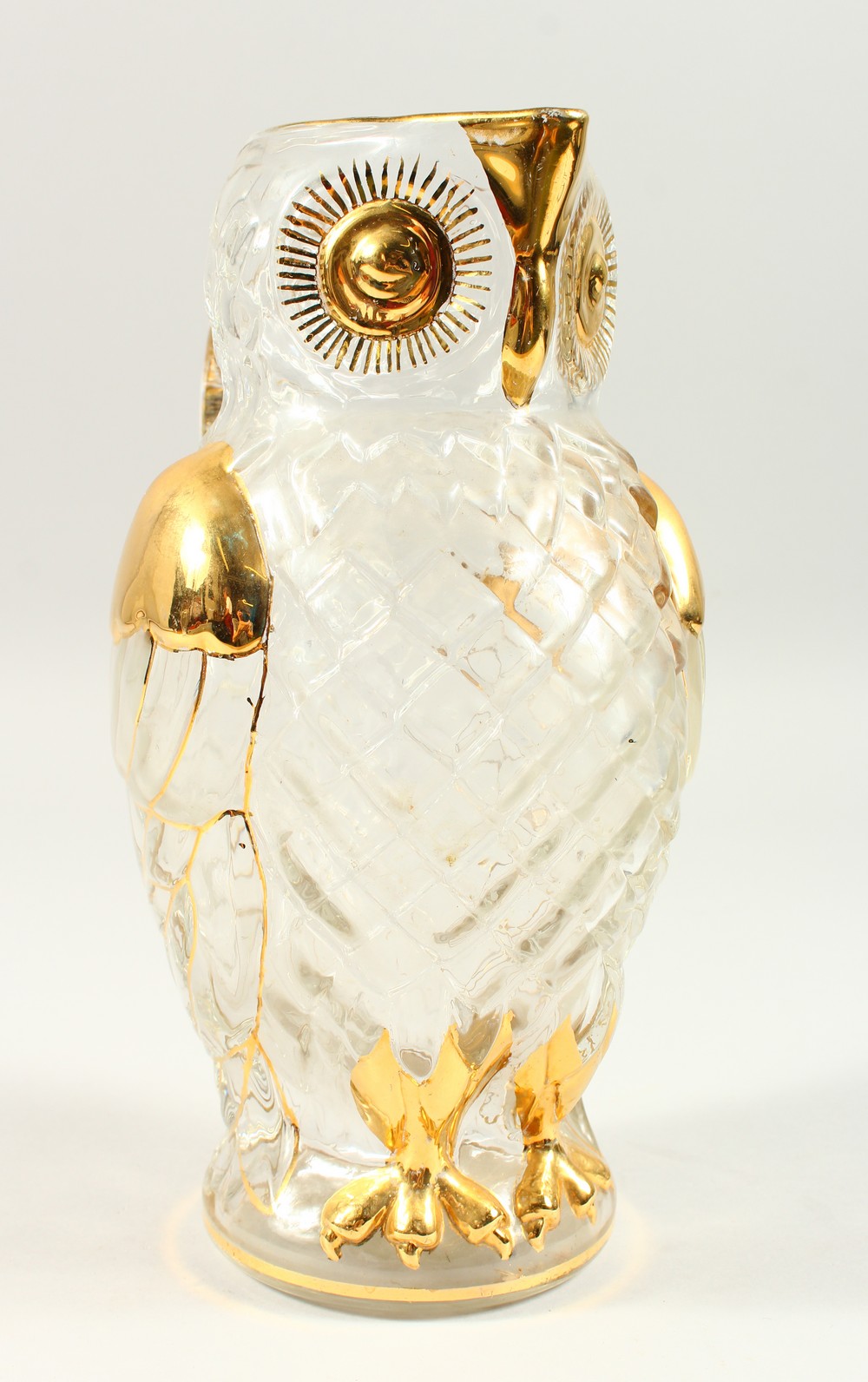 A MOULDED GLASS OWL SHAPE JUG, with gilded decoration. 26cms high.