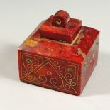 A CARVED RED MARBLE SEAL, inset with semi-precious stones. 7cms wide.