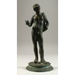 AFTER THE ANTIQUE A BRONZE STANDING MALE NUDE, on a circular base. 27cms high.