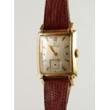 A 1930'S GOLD OMEGA WRISTWATCH, with leather strap.