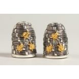 A PAIR OF .800 SILVER BEEHIVE SALT AND PEPPERS.