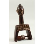 AN AFRICAN CARVED WOOD FIGURAL PULLEY. 16cms high.