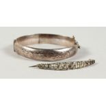 A SILVER BANGLE AND A BROOCH.