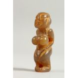 A CARVED HARDSTONE PENDANT, in the form of a naked woman. 7cms long.