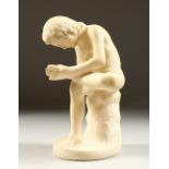 A CARVED ALABASTER GROUP, young boy removing a thorn from his foot. 21cms high.