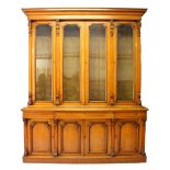 A VICTORIAN OAK LIBRARY BOOKCASE, with a moulded cornice above four glazed doors enclosing