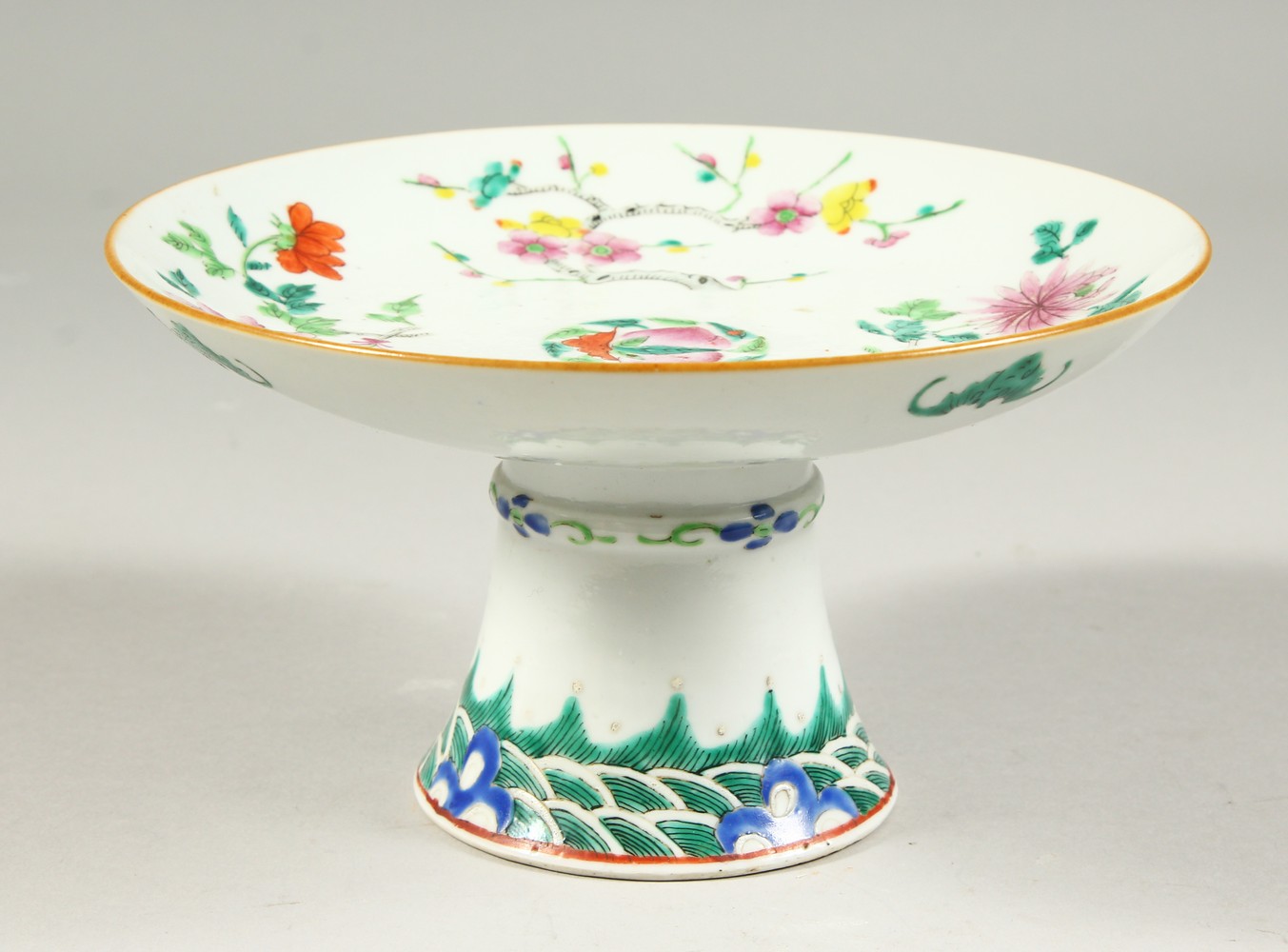 A PORCELAIN PEDESTAL DISH, decorated with flowers. 18.5cms diameter.