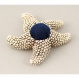 A SILVER STARFISH PIN CUSHION.