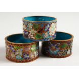 THREE JAPANESE MEIJI PERIOD CLOISONNE ENAMEL SERVIETTE RINGS, 5.3cm.