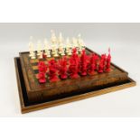 A GOOD 19TH CENTURY CHINESE CARVED & STAINED IVORY CHESS SET WITH GOLD LACQUER FOLDING GAMES BOARD /
