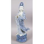 A LARGE 19TH CENTURY CHINESE BLUE & WHITE PORCELAIN FIGURE OF GUANYIN, stood upon a styl;ized rock