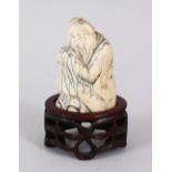 A GOOD 18TH CENTURY CHINESE CARVED IVORY FIGURE OF A BUDDHA / SAGE, in a crouched position with