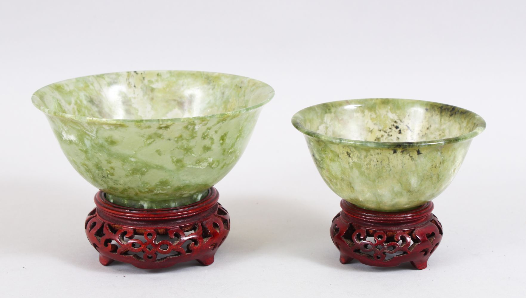 A GOOD PAIR OF 20TH CENTURY CHINESE GREEN JADE / HARDSTONE BOWLS, with accompanying carved stands,