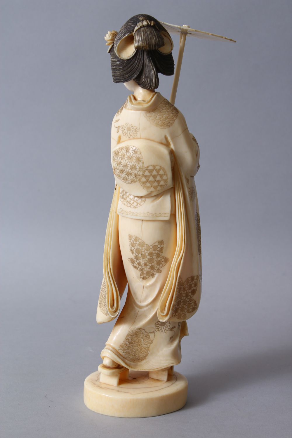 A GOOD JAPANESE MEIJI PERIOD CARVED IVORY OKIMONO OF A GEISHA GIRL, stood holding an umbrella and - Image 3 of 8