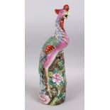 A 19TH / 20TH CENTURY CHINESE FAMILLE ROSE PORCELAIN FIGURE OF A PHOENIX BIRD, stood on a