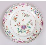 A GOOD 18TH CENTURY CHINESE FAMILLE ROSE PORCELAIN PLATE, decorated with scenes native flora, 22.5cm