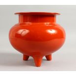 AN UNUSUAL CHINESE CORAL GROUND CIRCULAR CENSER on three legs. Six character mark. 8ins diameter.