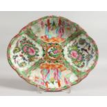 A CANTON OVAL DISH with four panels of birds, butterflies and flowers. 10ins wide.