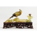A GOOD 19TH CENTURY CHINESE CARVED JADE GROUP OF TWO BIRDS on a pierced wooden stand. 6ins long.
