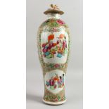 A 19TH CENTURY CANTON VASE AND COVER with panels of figures, flowers etc. 16ins high.