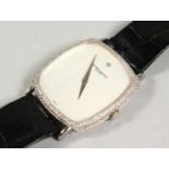 A GOOD 18CT WHITE GOLD VACHERON CONSTANTINE WRISTWATCH surrounded by diamonds, with leather strap