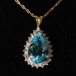 A 9CT GOLD, BLUE TOPAZ AND DIAMOND DROP PENDANT.