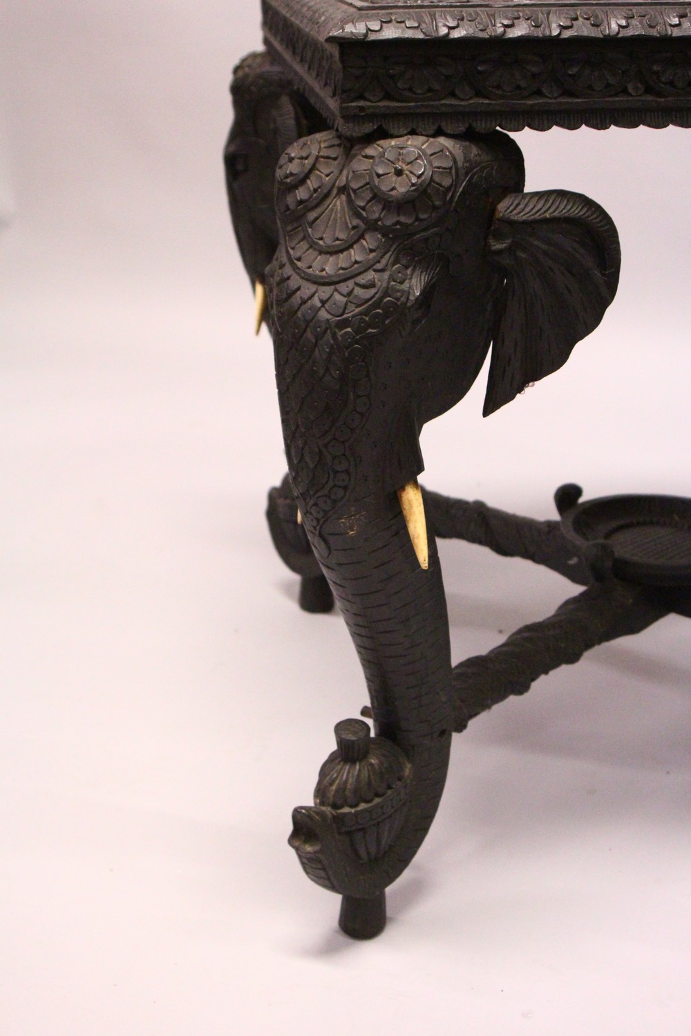 AN EARLY 20TH CENTURY CEYLONESE CARVED EBONY LOW TABLE, with an elephant head leg to each corner. - Image 5 of 5