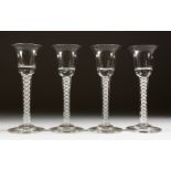 A SET OF FOUR WHITE OPAQUE AIR TWIST STEM WINE GLASSES with inverted bell bowls. 6ins high.