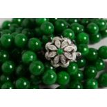 A GOOD DOUBLE ROW OF JADE BEADS, with 18ct white gold and diamond clasp. 25ins long.