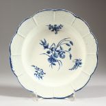 AN 18TH CENTURY WORCESTER PLATE, basket weave moulded and decorated in under-glaze blue with country