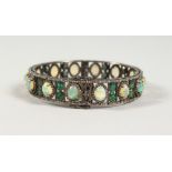 A SILVER OPENWORK BANGLE, set with opals and diamonds. 2.5ins diameter.
