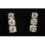 A GOOD PAIR OF 18CT WHITE GOLD THREE-STONE GRADUATED SET OF DIAMOND EARRINGS of 1.9CTS.