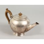 A GEORGIAN TEAPOT with wooden handle. London 1932. Maker: B. & F. Ltd. Weight 22ozs.