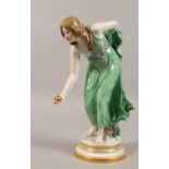 A VERY GOOD MEISSEN FIGURE OF A YOUNG LADY PLAYING BOWLS, holding a golden ball in her hand. Cross