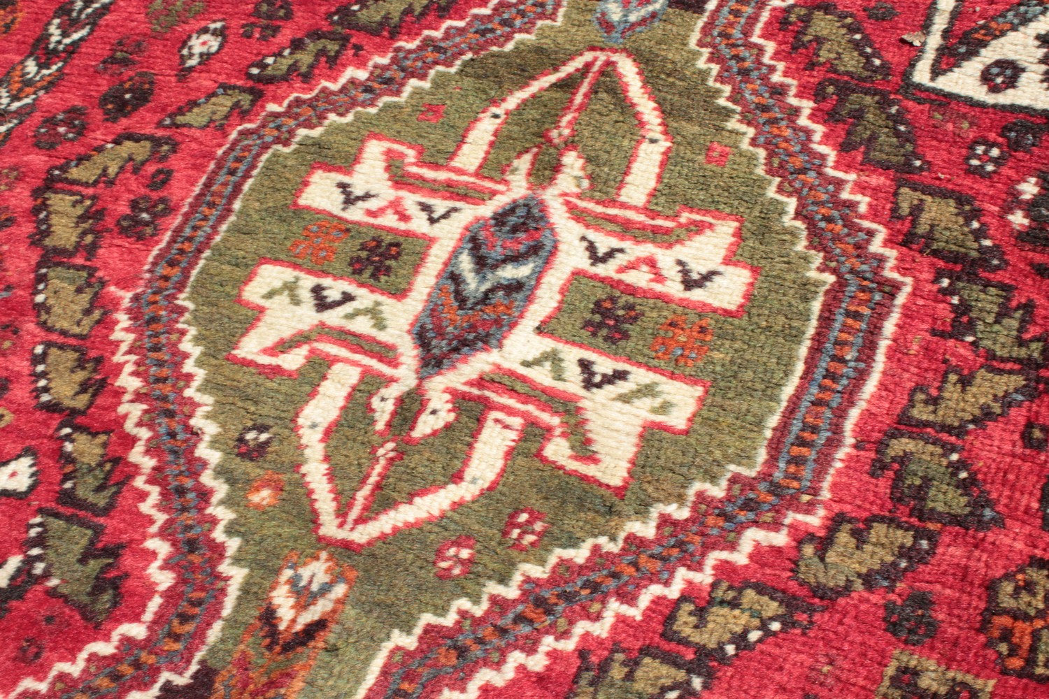 A PERSIAN TRIBAL SHIRAZ QASHQAI CARPET with a large motif on a red ground. 11ft 6ins x 5ft 6ins. - Image 3 of 8