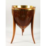 A MAHOGANY JARDINIERE, on curving legs with brass liner. 22ins high.