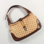 A GUCCI BROWN LEATHER AND CREAM MATERIAL BAG.