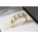 A 9CT GOLD FOUR-STONE OPAL AND DIAMOND RING.