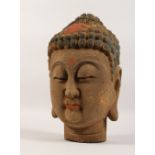A LARGE CARVED AND PAINTED HEAD OF BUDDHA. 16ins high.