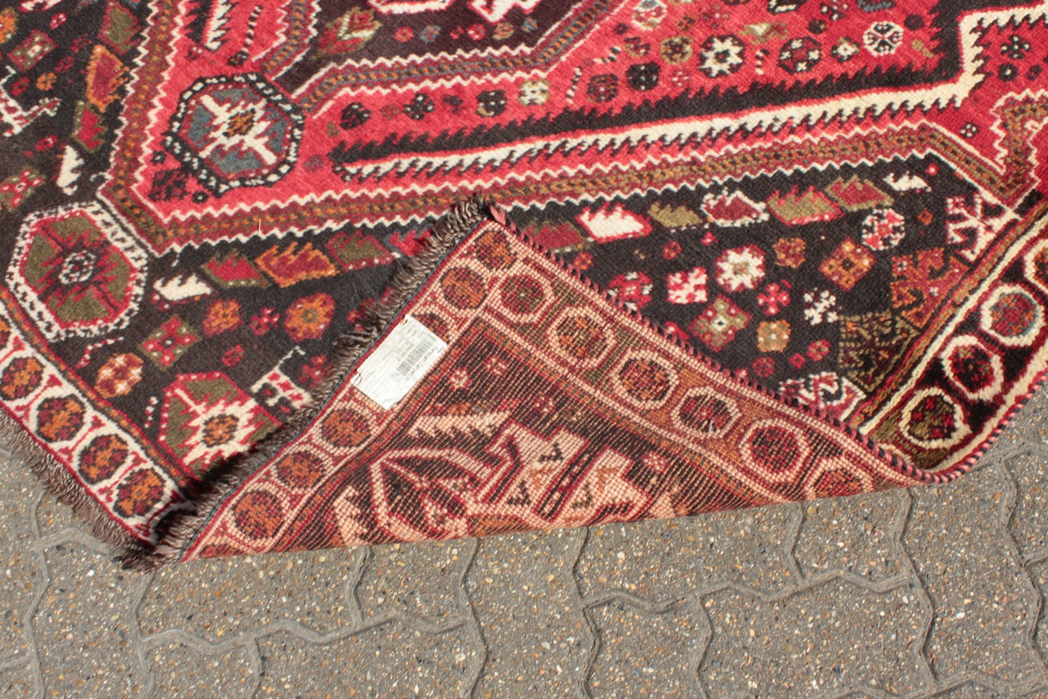 A PERSIAN TRIBAL SHIRAZ QASHQAI CARPET with a large motif on a red ground. 11ft 6ins x 5ft 6ins. - Image 7 of 8