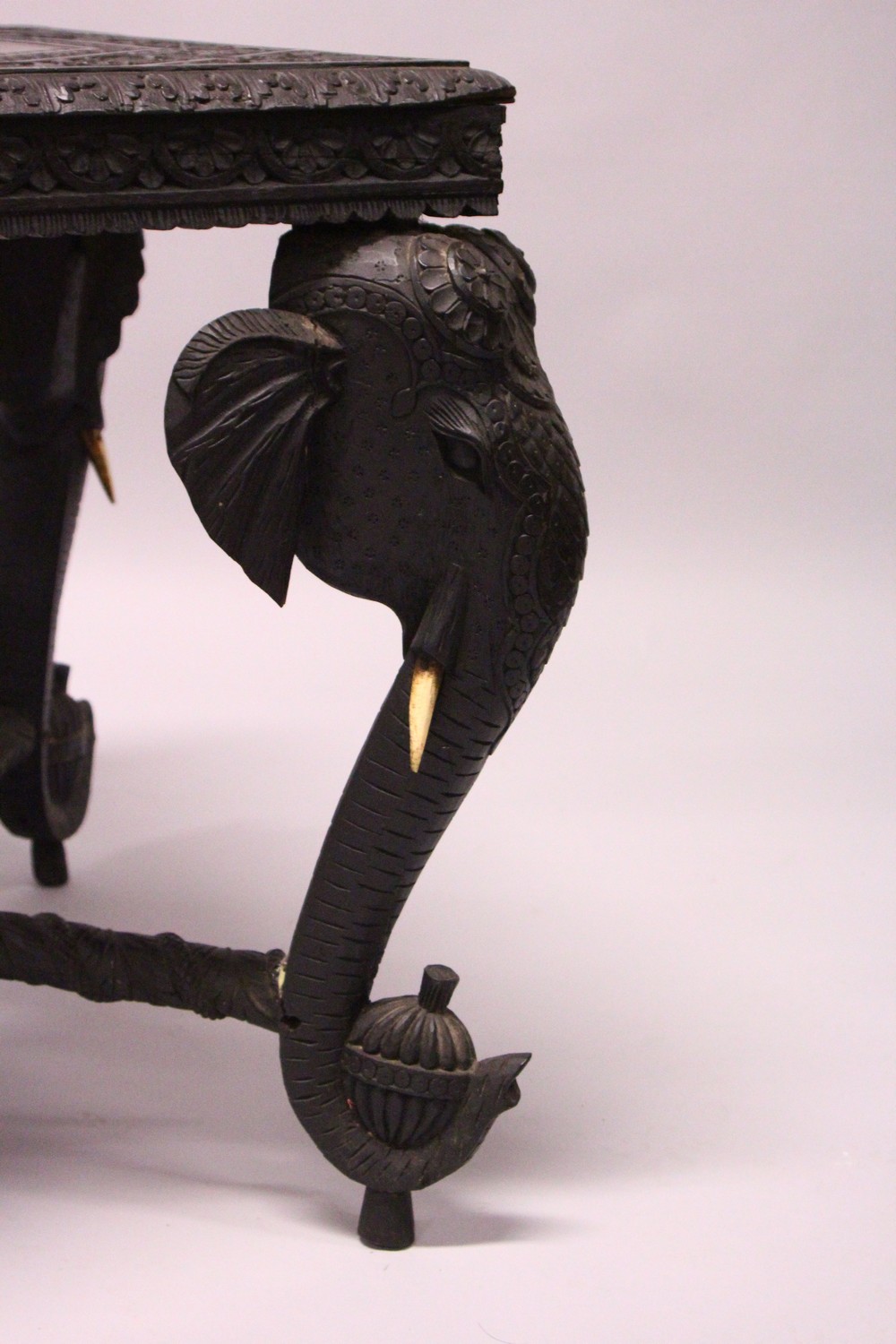 AN EARLY 20TH CENTURY CEYLONESE CARVED EBONY LOW TABLE, with an elephant head leg to each corner. - Image 4 of 5