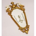 A FRENCH STYLE GILT FRAMED MIRROR, mounted with cherubs. 2ft 10ins high x 1ft 5ins wide.