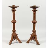 A PAIR OF GOTHIC STYLE CAST BRASS CANDLESTICKS. 18ins high.
