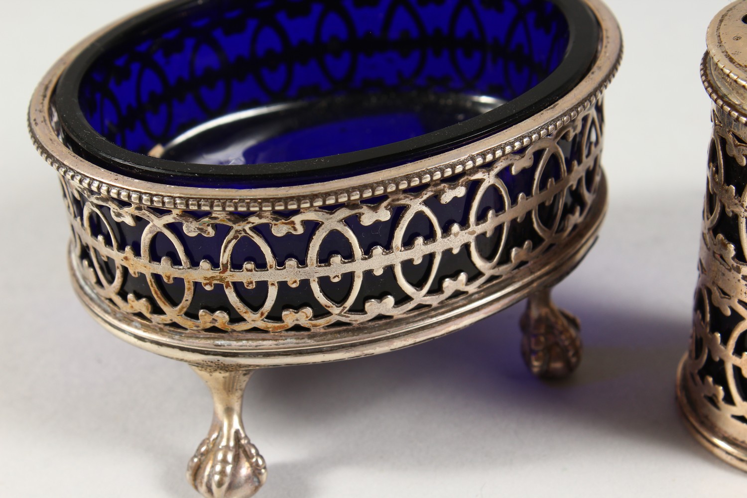 AN OVAL PIERCED SALT CELLAR with sapphire blue liner, London 1942, and A PEPPERETTE, London 1907 ( - Image 2 of 6
