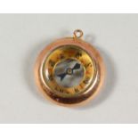 A TINY GOLD COMPASS.