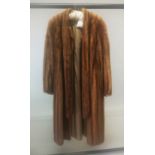 A LIGHT THREE QUARTER LENGTH FUR COAT.