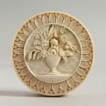 A GOOD SMALL FRENCH IVORY CIRCULAR PILL BOX, the lid carved with a vase of flowers. 2.25ins